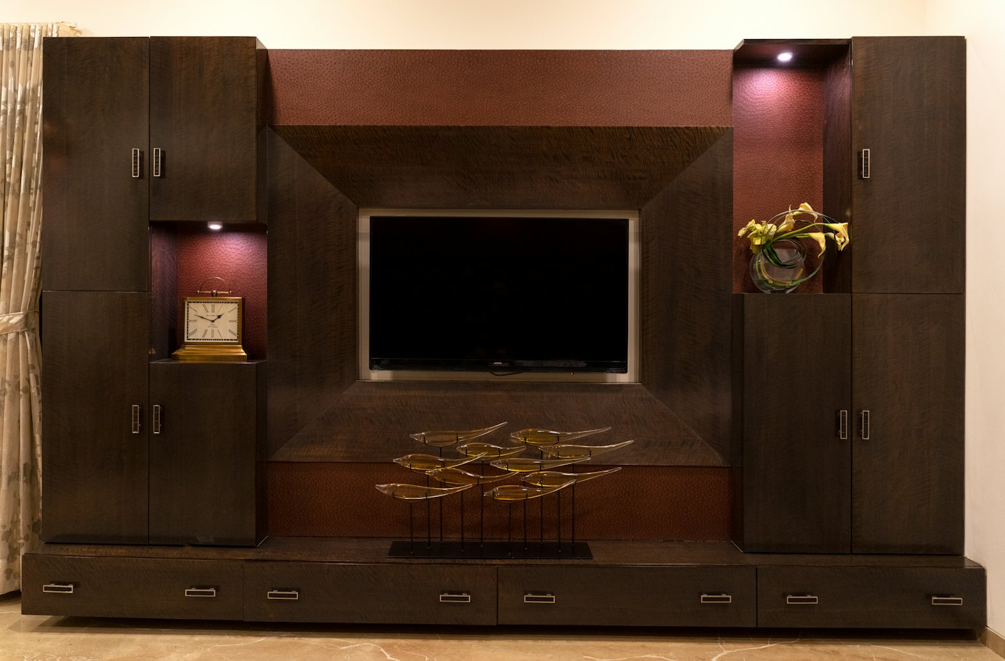 Custom wooden entertainment unit featuring a television and decorative shelves.