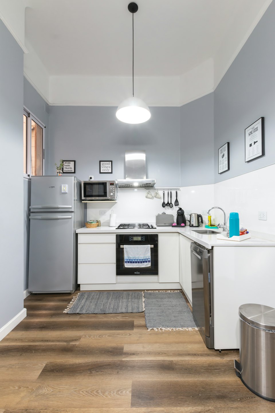 L-shaped kitchen with blue walls and white cabinets.